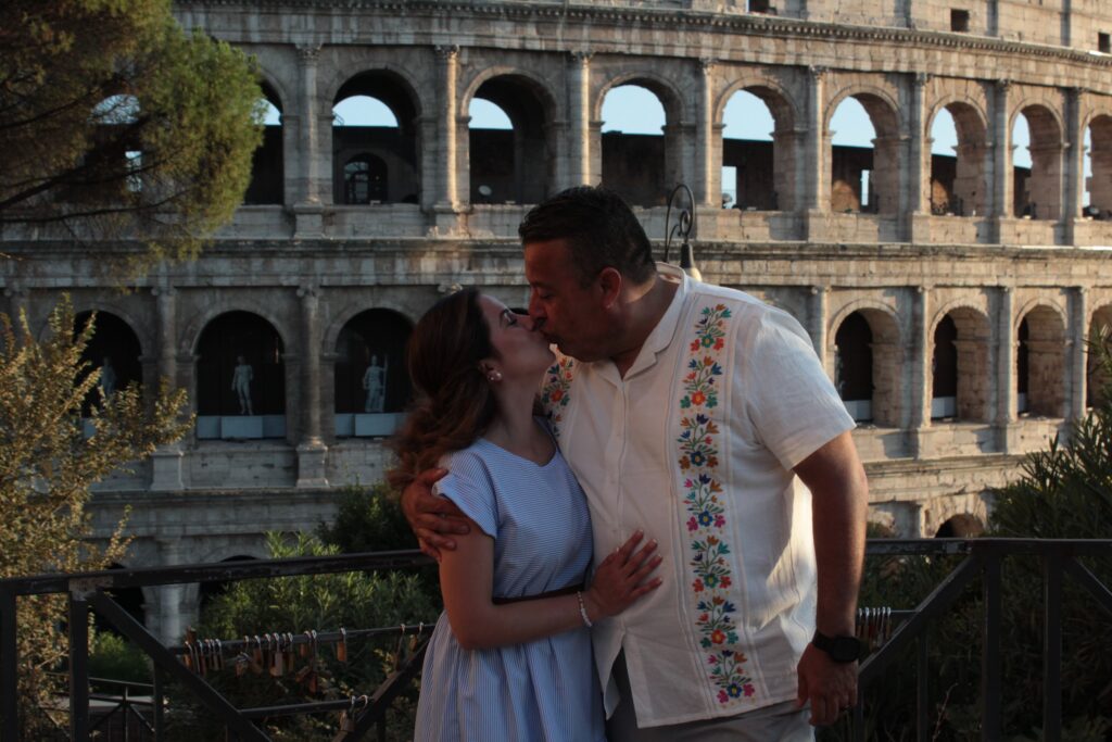 A couple sharing a kiss in front of the Colosseum