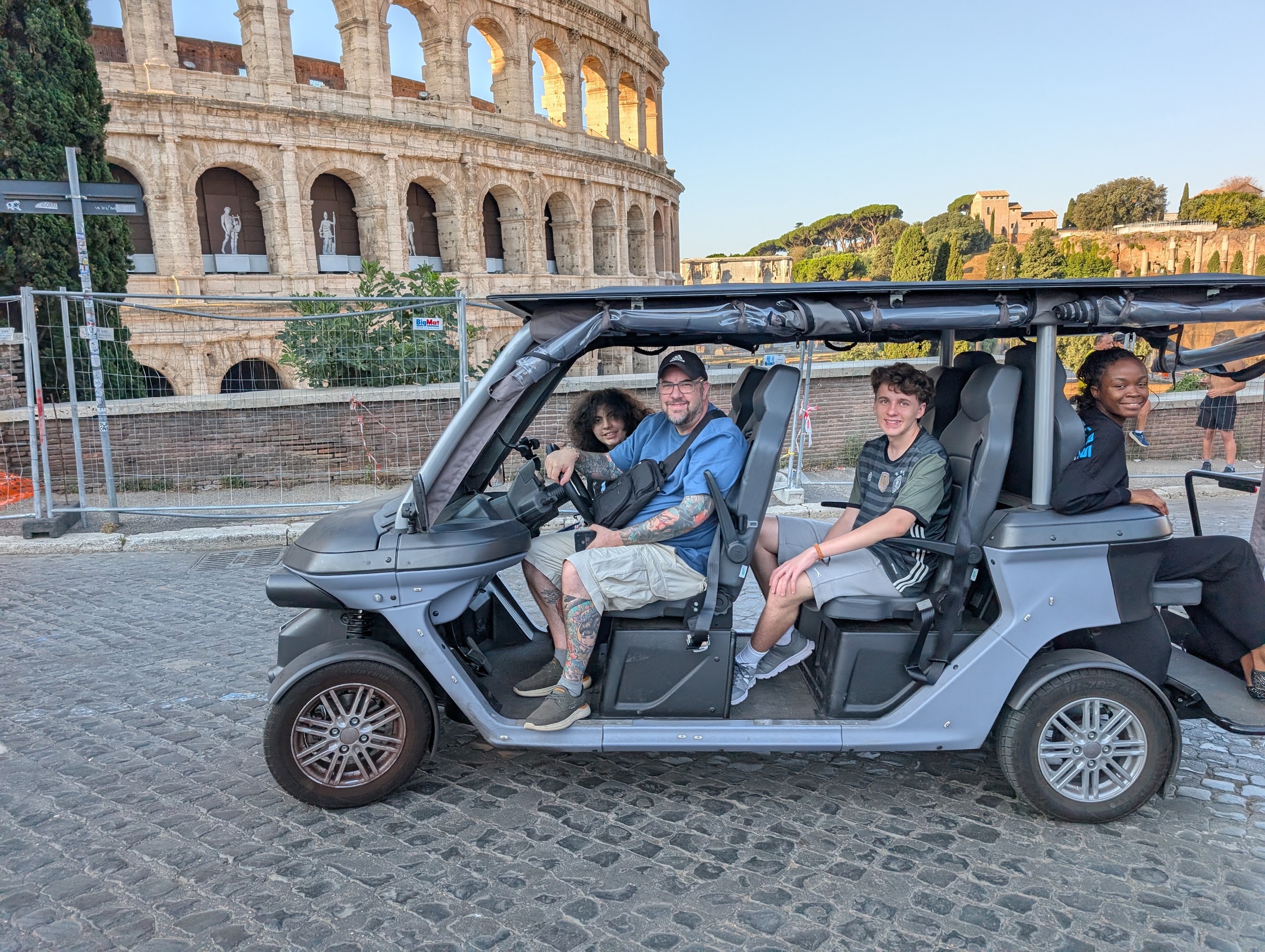 Guests on a golf cart tour by the Colosseum