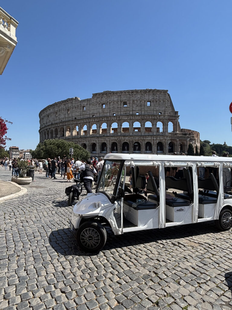 Electric golf cart parked in front of the Colosseum on a private Rome tour