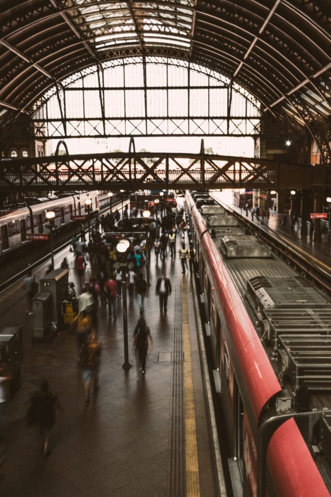A busy railway platform with a train alongside