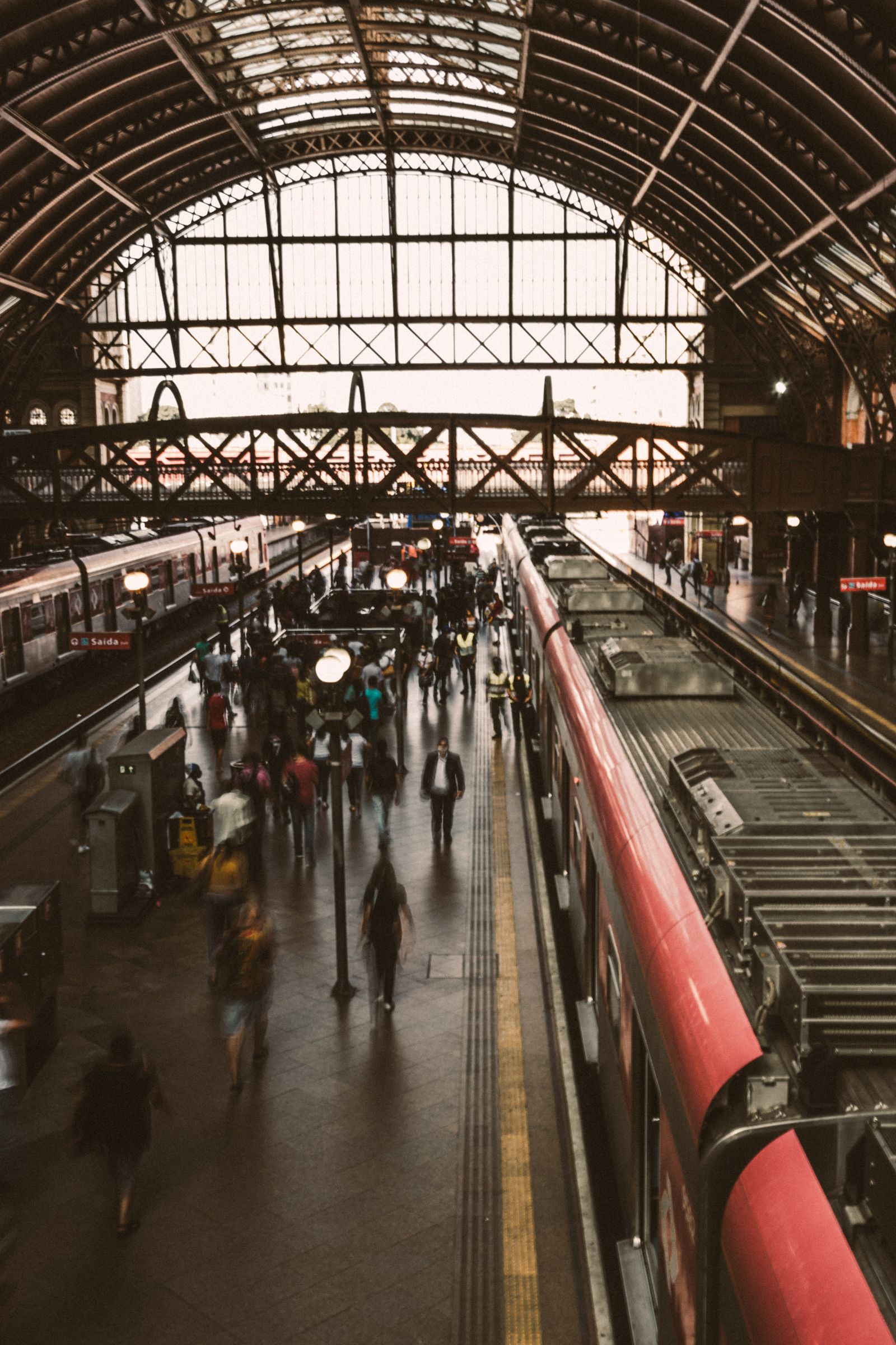 A busy railway platform with a train alongside